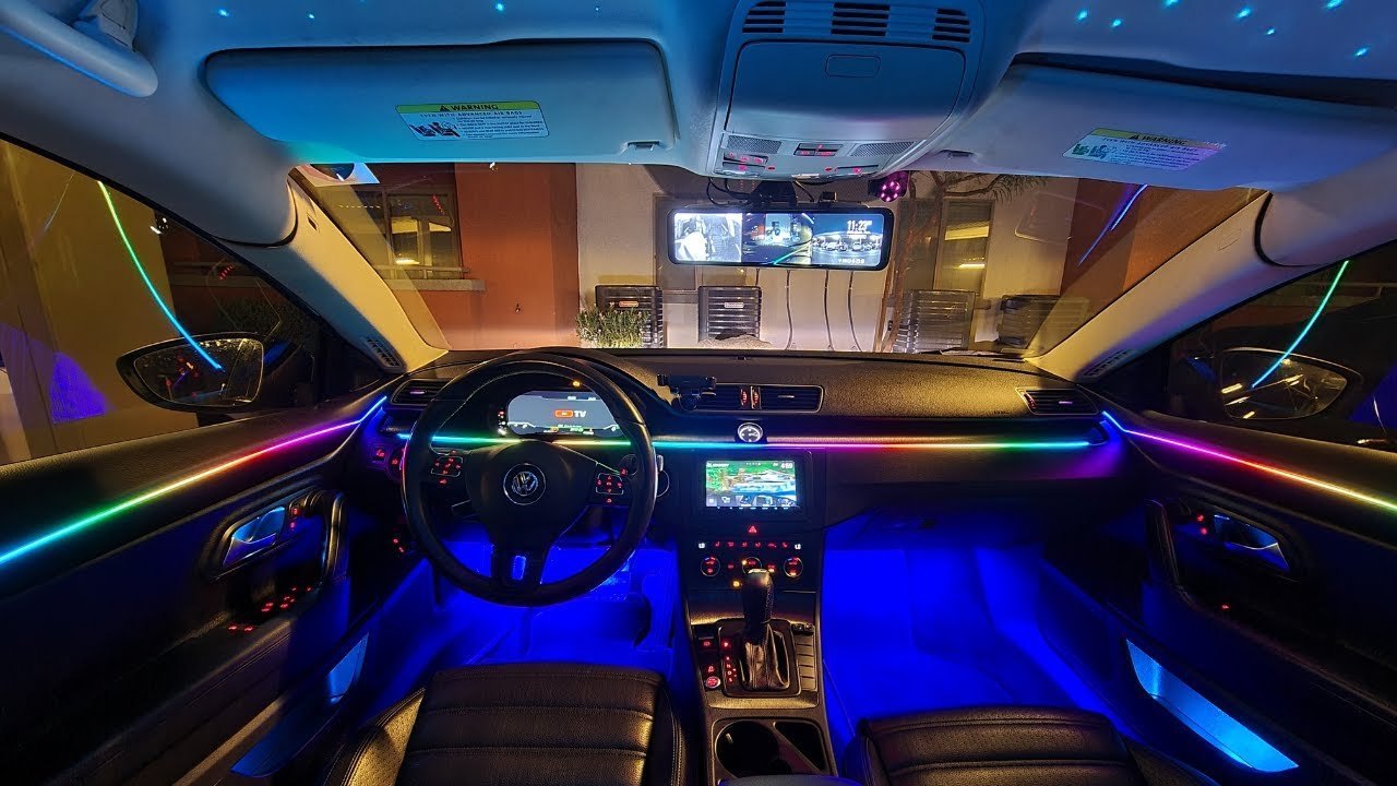Multi-color RGB ambient lighting kit illuminating the dashboard and footwells of a car interior